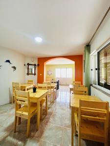 a dining room with wooden tables and chairs at Casa BB&Djassi - SUITES in Ponta do Sol