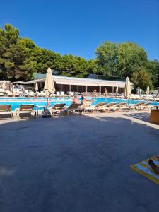 a swimming pool with lounge chairs and umbrellas at Villa Petra 1 in Vodice