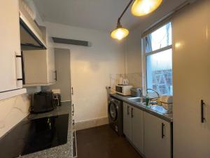 a kitchen with a sink and a washing machine in it at Rose Cozy House in Stockton-on-Tees