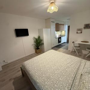 a white room with a bed and a tv at Flor- Sakura Gare Lausanne in Lausanne