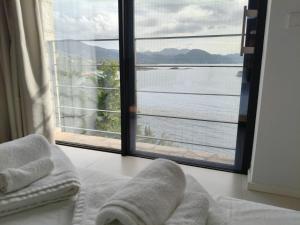 a bedroom with a large window with a view of the water at Villa Oikos in Syvota +3 photos
