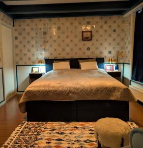 a bedroom with a large bed and a rug at De Tegel Suite in Anjum