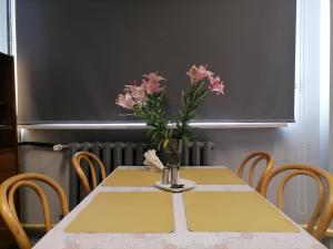 a table with a vase of pink flowers on it at Center Apartment in Przemyśl +83 photos