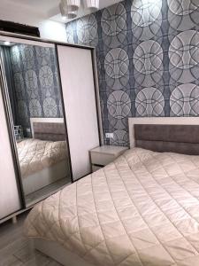 a bedroom with a bed and two mirrors at apartment in Itʼkhvisi