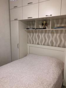a small bedroom with a bed and white cabinets at apartment in Itʼkhvisi