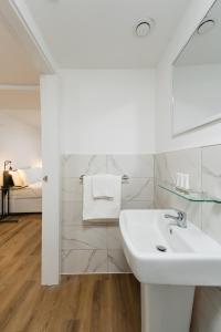 a white bathroom with a sink and a bed at 8 Stanley Street Apart-Hotel in Liverpool +62 photos