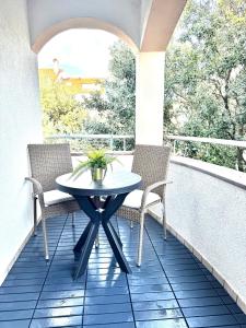 ein Tisch und zwei Stühle auf einer Veranda in der Unterkunft Gold Apartment On The Beach in Novalja + 11 Fotos