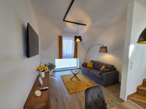 a living room with a couch and a table at Harmónia Apartmanház in Kőszeg