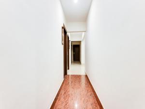 an empty corridor with white walls and wood floors at Townhouse Royal Inn in Guwahati +47 photos