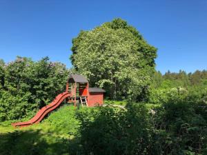 a playground with a slide on a hill at Sättraby villa in Norrtälje