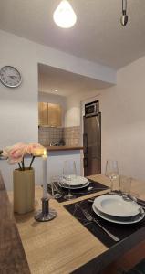 a kitchen with a table with plates and wine glasses at Ferienwohnung am Töpferberg in Löbau