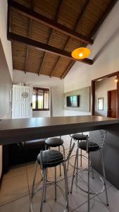 a kitchen with a large bar with stools in it at Pousada Kauai in Praia do Rosa