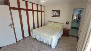 a small bedroom with a bed and a mirror at Varanda do forte in Cabo Frio