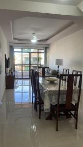 a dining table and chairs in a living room at Varanda do forte in Cabo Frio