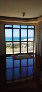 a room with a large window with a view of the ocean at Varanda do forte in Cabo Frio