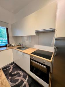 a kitchen with white cabinets and a stove top oven at Apartment Edi in Grgar