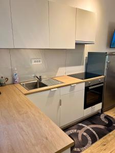 a kitchen with white cabinets and a sink at Apartment Edi in Grgar