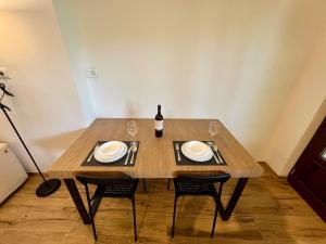 a wooden table with two chairs and a bottle of wine at Apartment Edi in Grgar