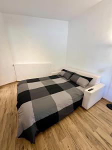 a bedroom with a black and white bed and wooden floors at Apartment Edi in Grgar +15 photos