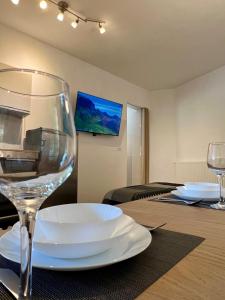 a table with a wine glass and plates on it at Apartment Edi in Grgar