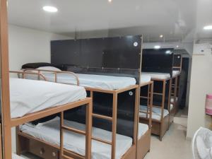 a row of bunk beds in a dorm room at Viresh Cottage in Solapur