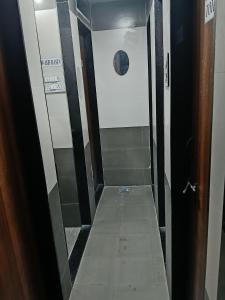 a bathroom with a walk in shower with a door at Viresh Cottage in Solapur