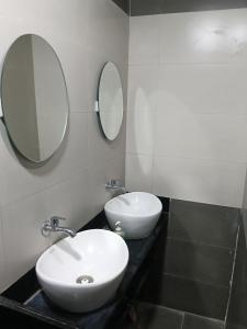 a bathroom with a white sink and a mirror at Viresh Cottage in Solapur