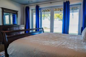 a bedroom with a bed with blue curtains and a window at Salty Bay Hideaway in Gulf Breeze