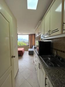 a kitchen with a sink and a view of a bedroom at Cozy suite and Jacuzzi overlooking the ocean in Volcán Chimborazo