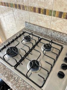 a stove top with four burners on a kitchen counter at Cozy suite and Jacuzzi overlooking the ocean in Volcán Chimborazo +3 photos