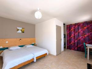 a bedroom with a bed and a table in it at Le Mas des 3 Anes in Blars