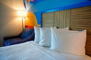 a bed with pillows and a chair in a hotel room at Castaway Bay by Cedar Point Resorts in Sandusky