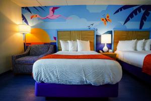 a hotel room with two beds and a chair at Castaway Bay by Cedar Point Resorts in Sandusky