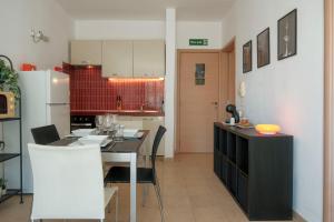 a kitchen with a table and a white refrigerator at Porto by Shmoo! in Is-Swieqi