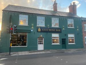 a green building with a sign that reads kyi wine bar at Spacious 4 Bed House Sleeps 8 in Quorn Near Loughborough in Quorndon
