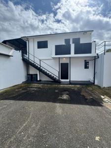 a white building with a staircase on the side of it at Brand New Luxe 2BR Apt Near SJU & Airport in Carolina