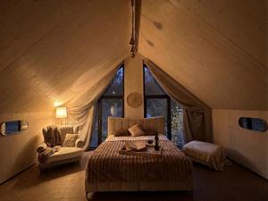 a bedroom with a large bed in a tent at Cëchô Woda in Parchowo