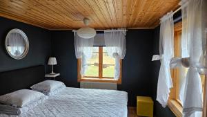 a bedroom with a bed and a window at Kilsborgs Gård - Lakehouse in Svanskog