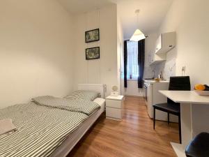 a small bedroom with a bed and a kitchen at Chińczyk in Inowrocław