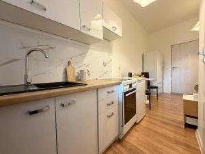 a kitchen with white cabinets and a sink at Chińczyk in Inowrocław