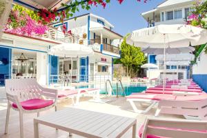 a group of chairs and umbrellas next to a pool at MERVE BUTİK OTEL in Didim