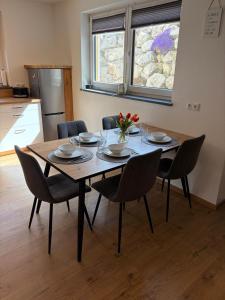 a dining room table with chairs and a vase of flowers at Ferienwohnung Alpenblick in Wessobrunn