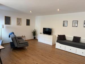 a bedroom with a bed and a chair and a television at Ferienwohnung Alpenblick in Wessobrunn +26 photos