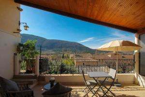 a patio with a table and an umbrella at Studio Walla Confort Centre in Montbrun-les-Bains