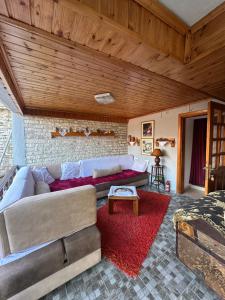 a living room with a couch and a red rug at Mani Guest House in Gjirokastër