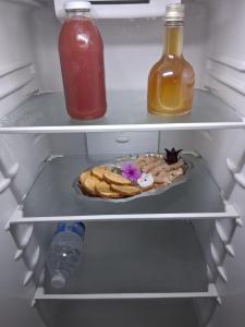 a refrigerator with a plate of food and a bottle of juice at Bungalow Milo in Bouillante