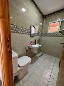 a bathroom with a toilet and a sink at Bord de Mer kelibia ezzahra in Ḩammām al Ghazzāz