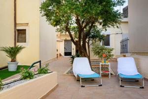 two chairs and a table in a courtyard with a tree at Lithinon House in Chania