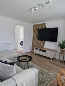 a living room with a flat screen tv on a wall at Justina's House in East Kilbride