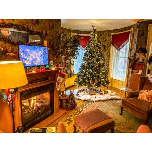 a living room with a christmas tree and a fireplace at Bentley House Bed and Breakfast in Poultney